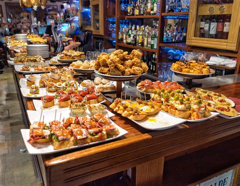 Bar and tapas - Tapas are meant to be shared. In Madrid and Seville, for example, it’s normal for groups of friends to go out on a tapas crawl. This means going from bar to bar, and at each stop, each person orders a drink (beer, wine, cava, etc.) accompanied by a small bite-size tapa or two. A tapas crawl involves 3 or 4 stops.
